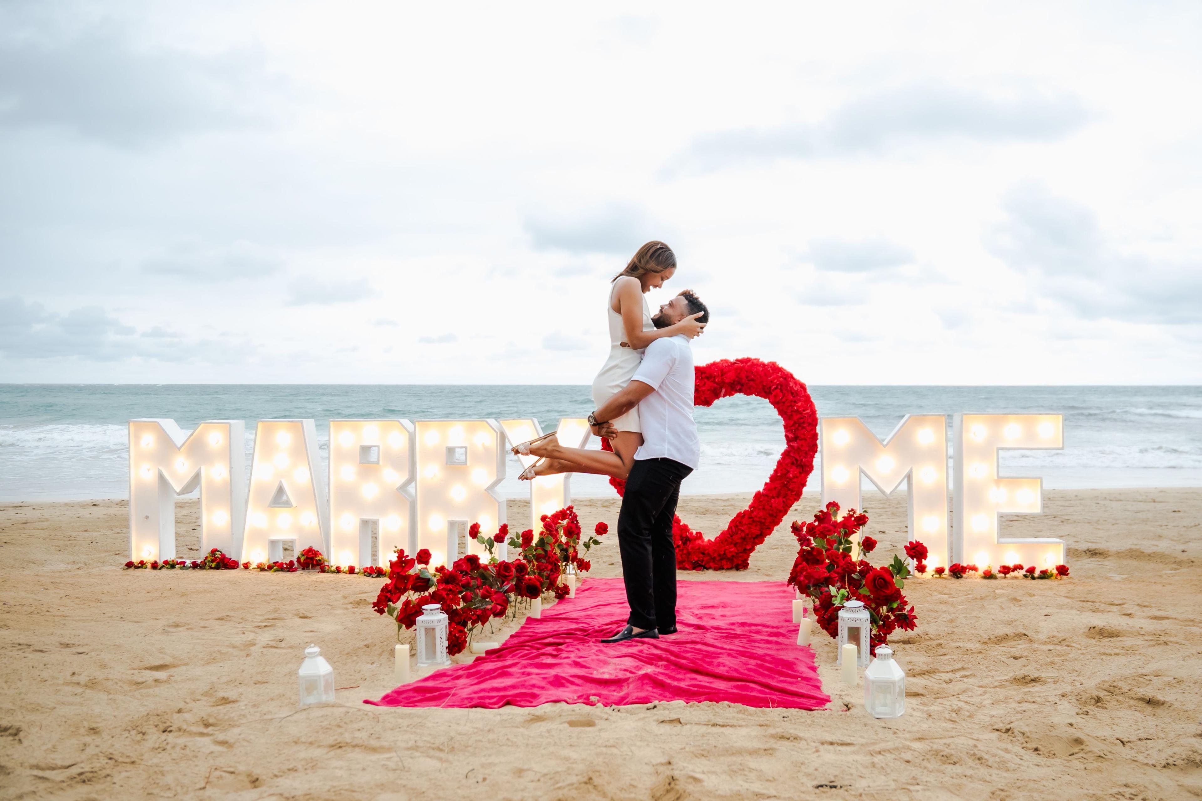 Pedido de casamento romântico em Punta Cana com velas, rosas, jantar privado na praia e decoração elegante ao pôr do sol