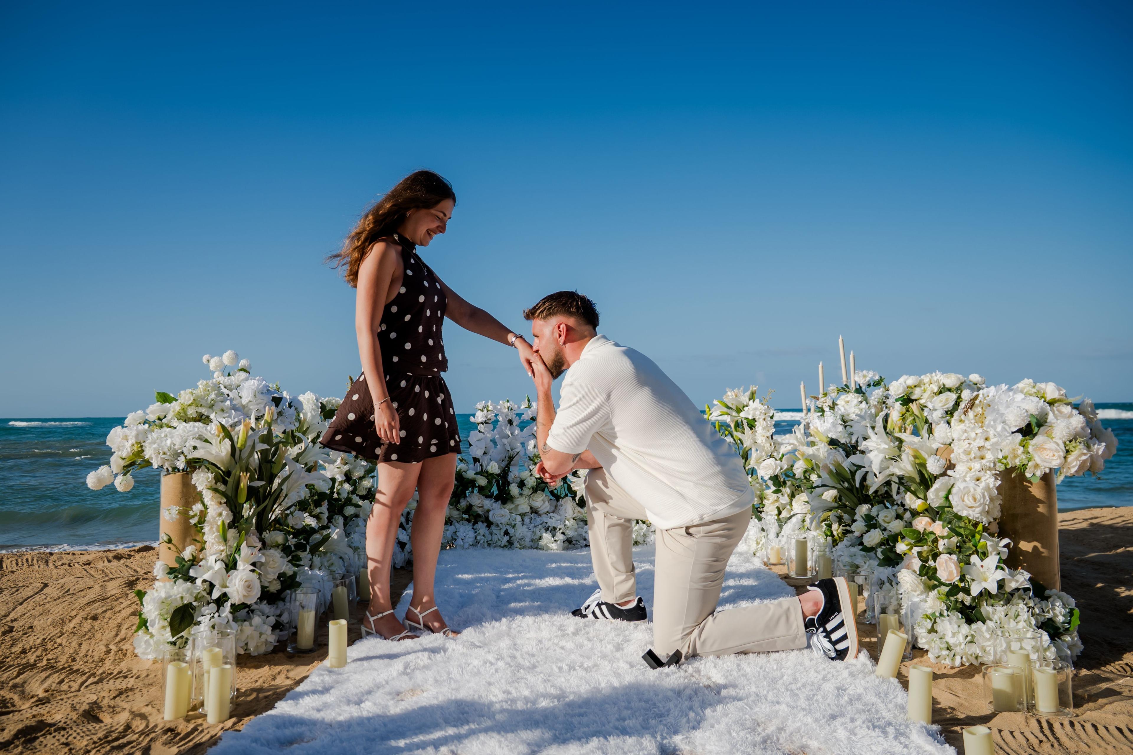 Romantic marriage proposal setup in Punta Cana with candles, roses and elegant beachfront decoration at sunset