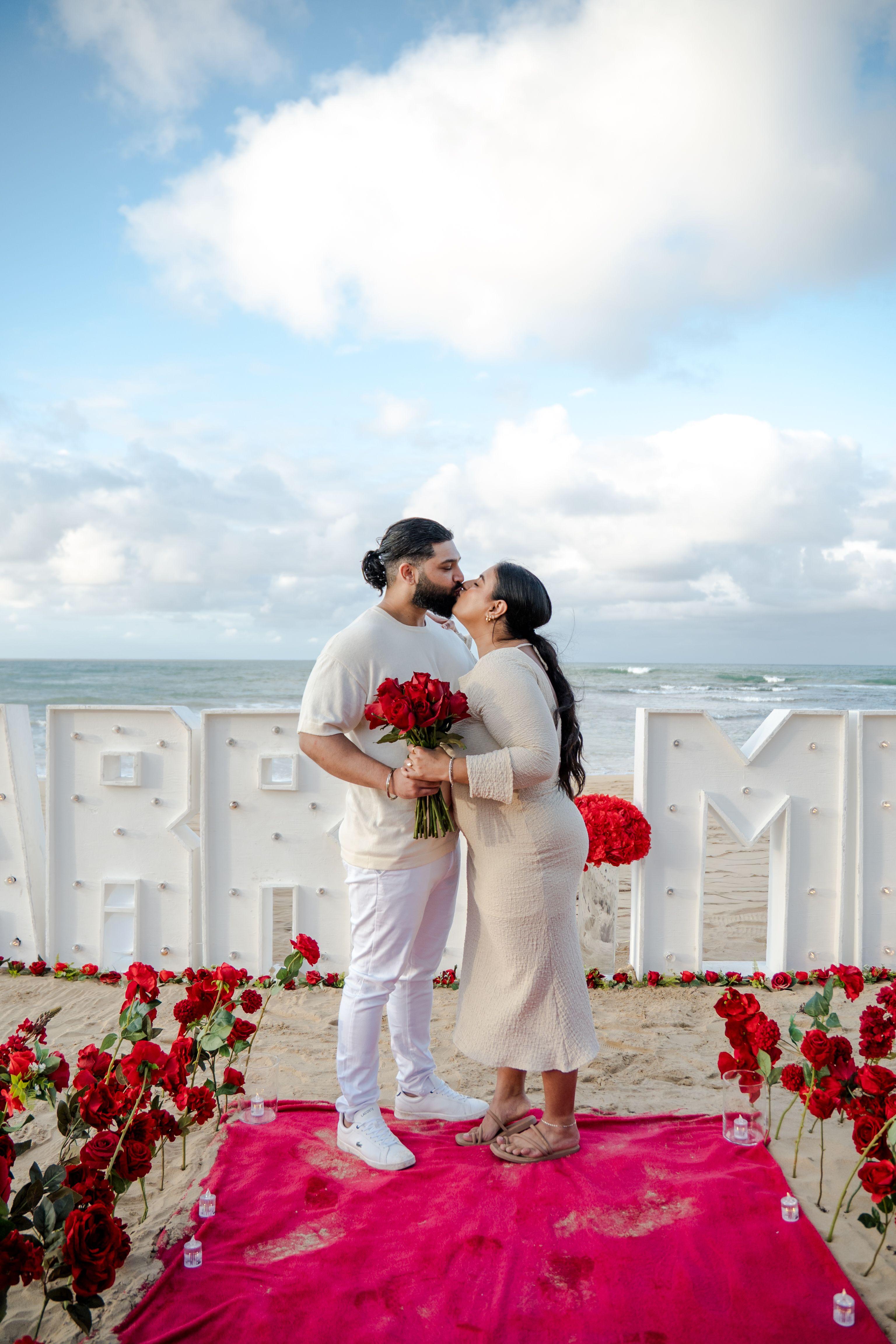 Romantischer Verlobungsantrag in Punta Cana mit Kerzen, Rosen und elegantem Dinner am Strand bei Sonnenuntergang