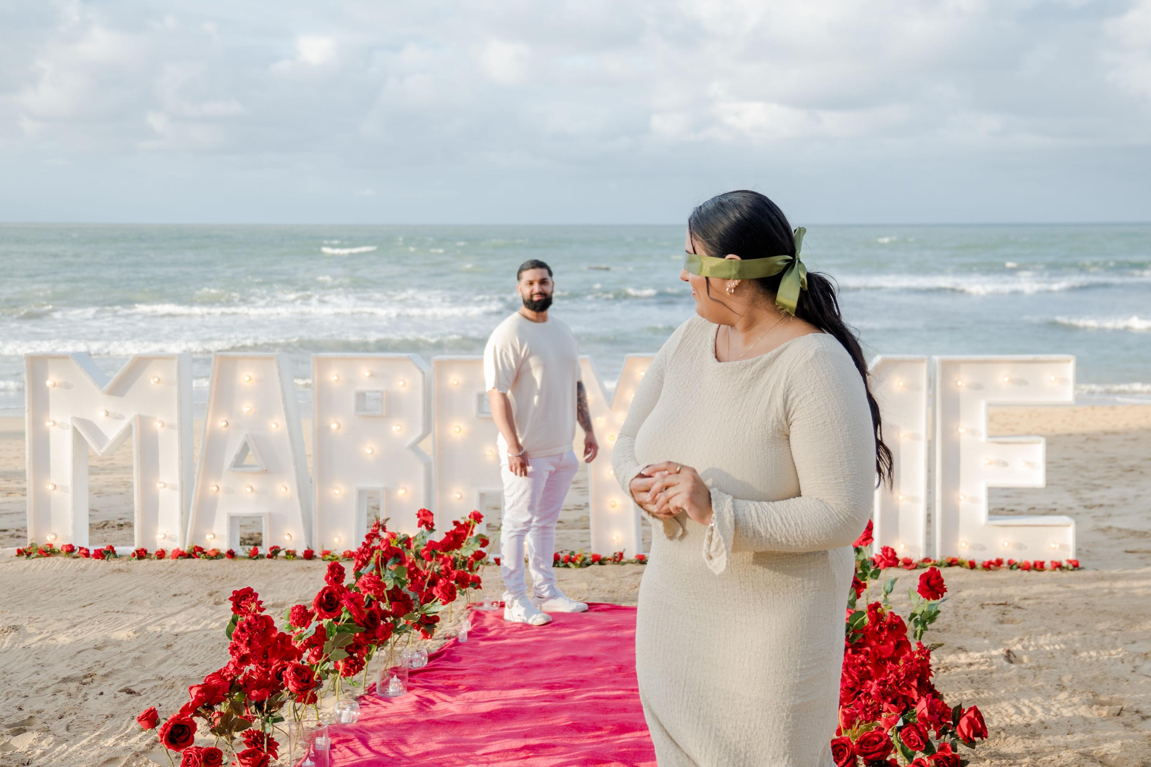 Romantic engagement proposal setup in Punta Cana with candles, roses and elegant beachfront dinner at sunset