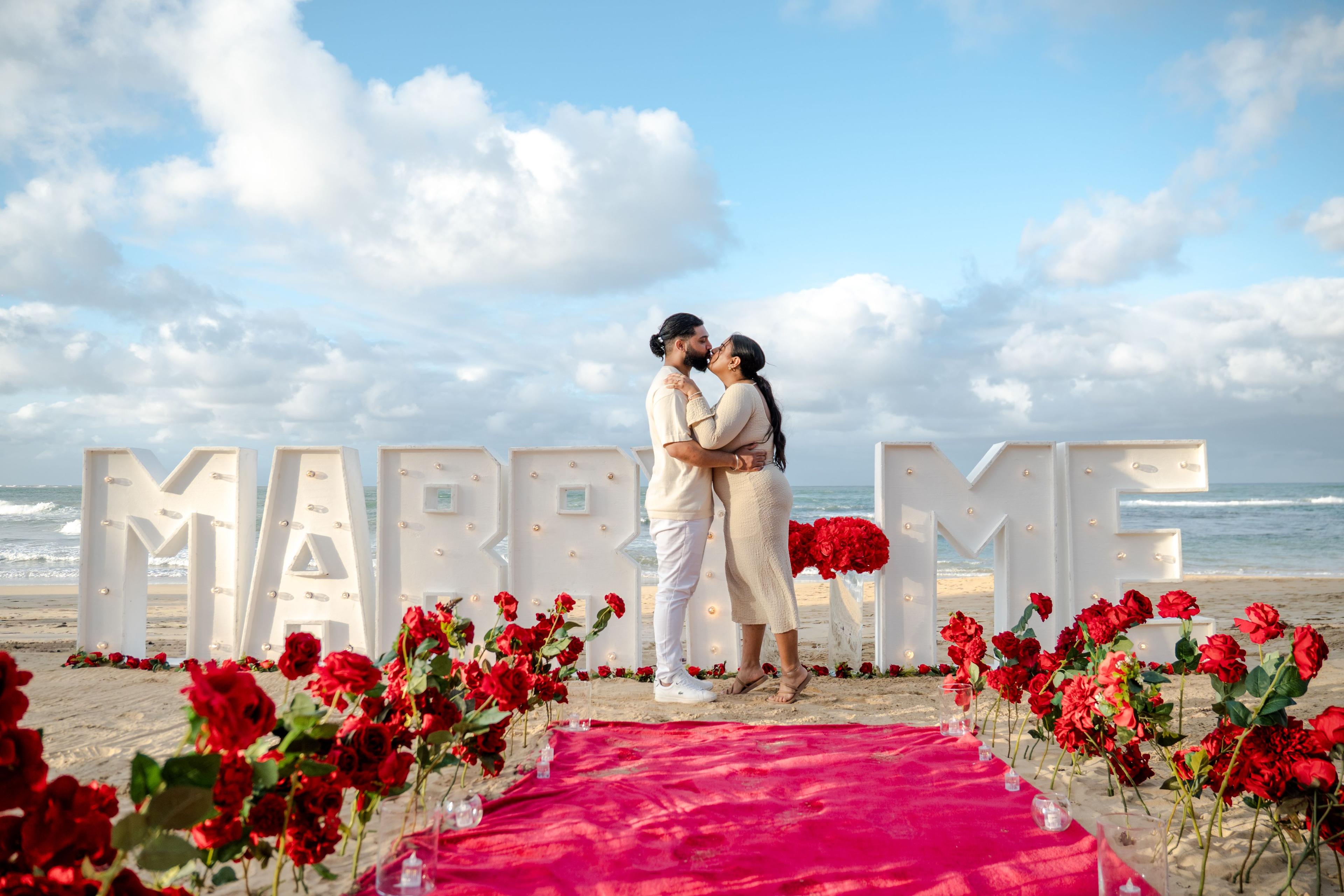 Propuesta de compromiso romántica en Punta Cana con velas, rosas y cena elegante frente al mar al atardecer