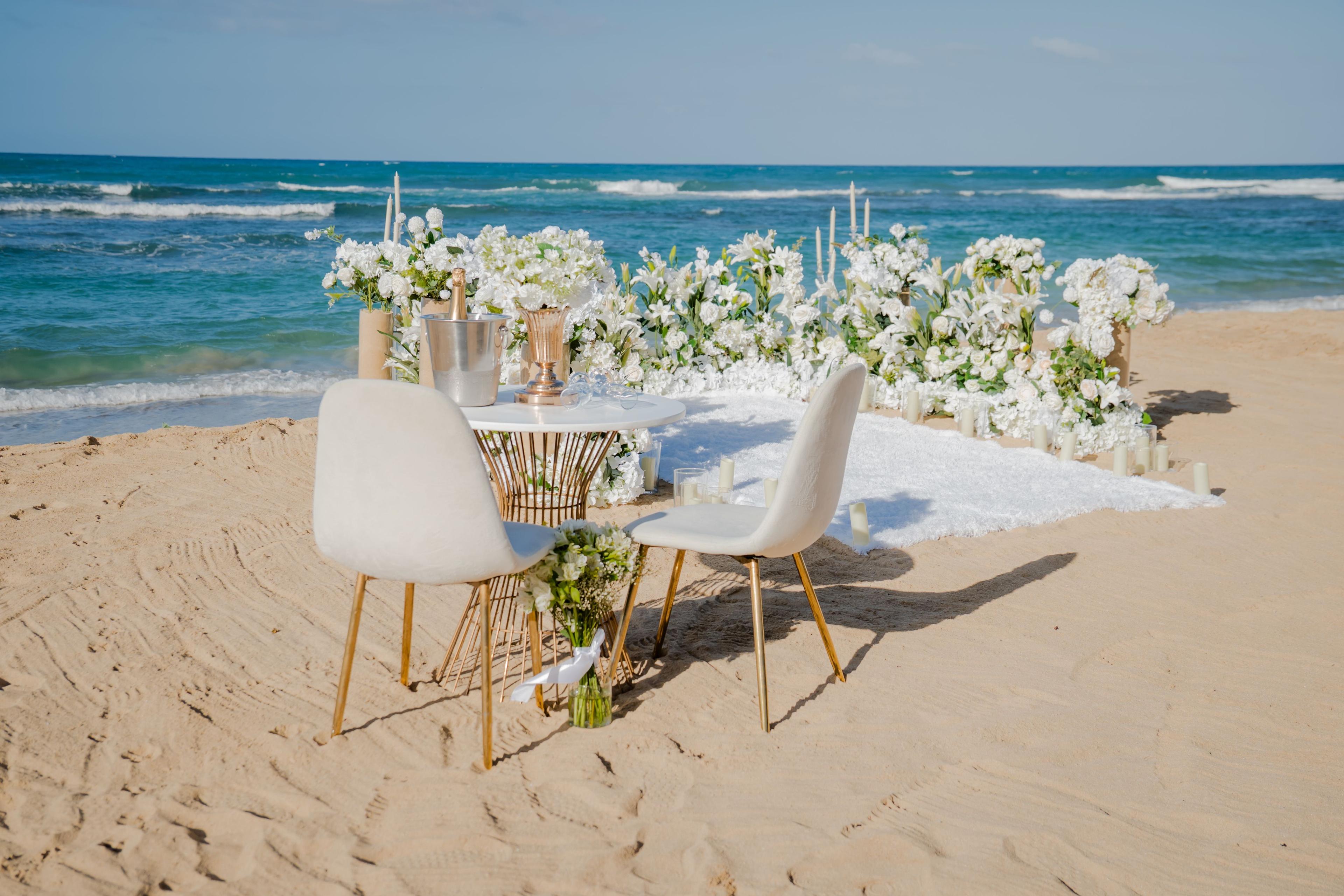 Demande en mariage romantique à Punta Cana avec bougies, roses et décoration élégante sur la plage au coucher du soleil