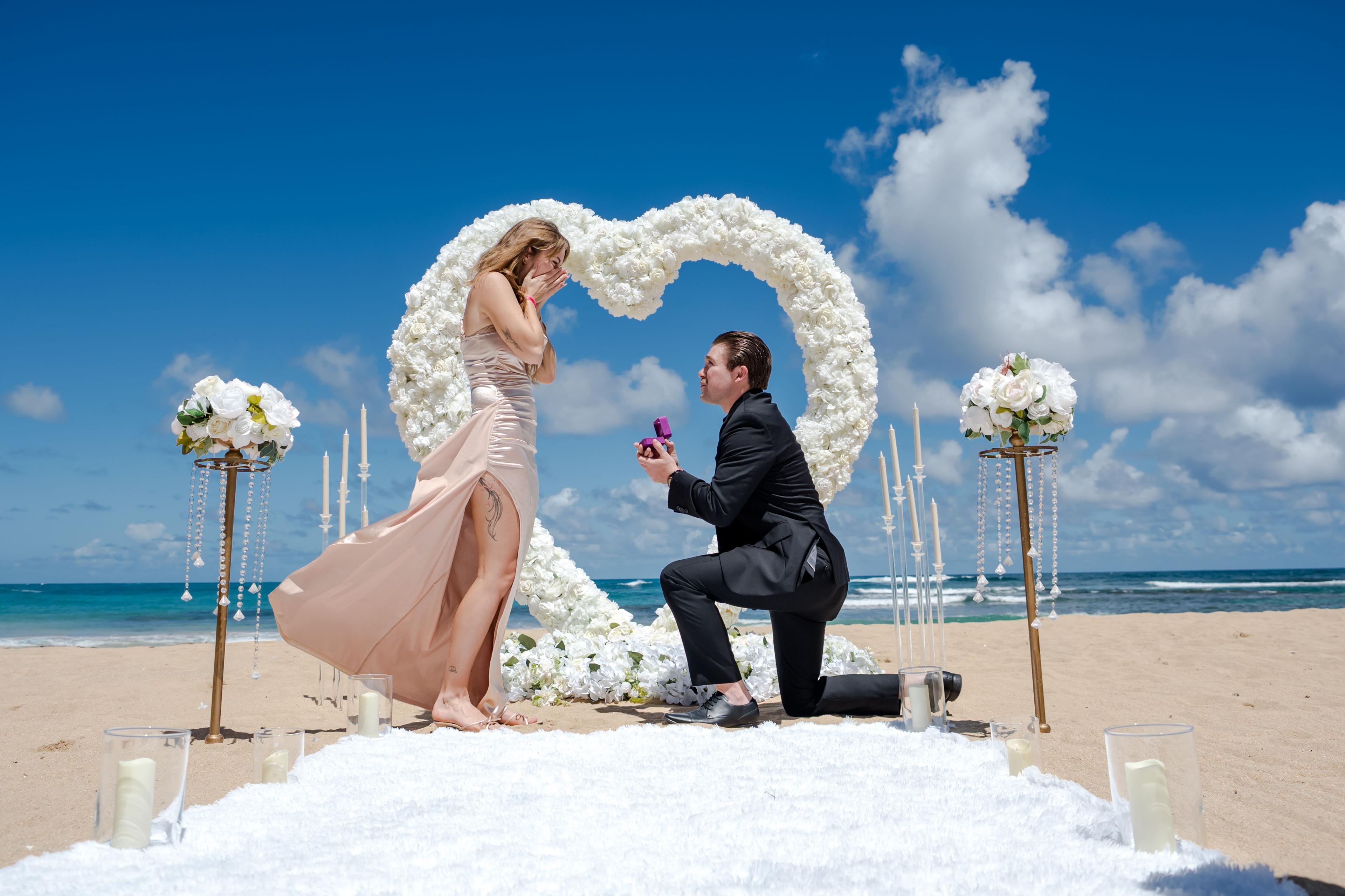 Romantic proposal setup in Punta Cana with candles, roses, beachfront dinner and elegant sunset engagement decoration